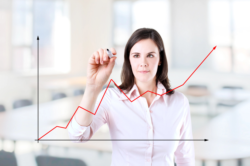 Image of business woman drawing a chart showing growth