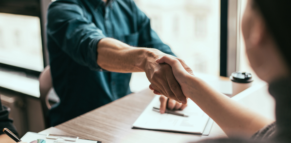 close of up handshake between two people symbolising commitment