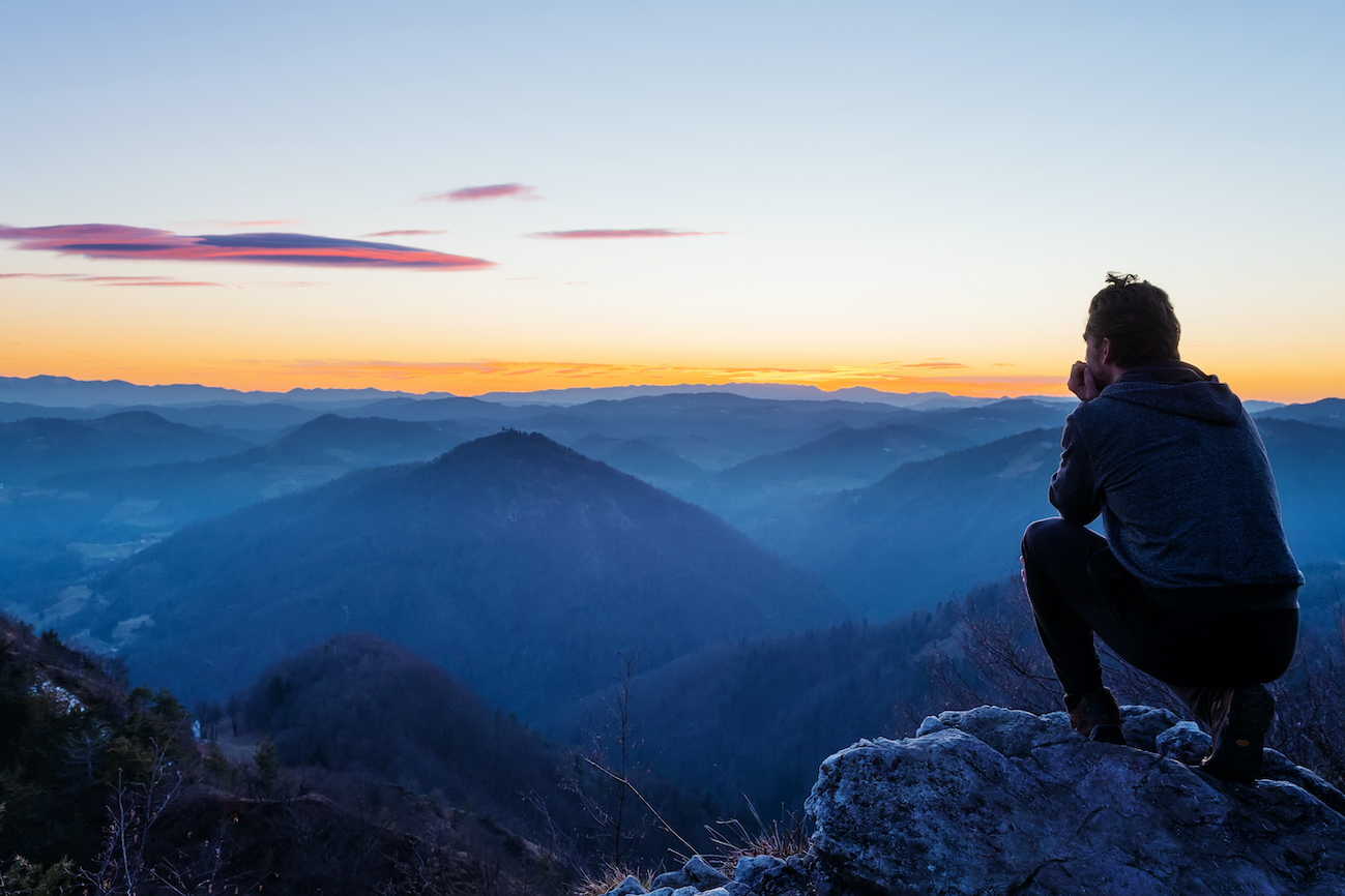 image of person taking time to reflect whilst looking out over mountains